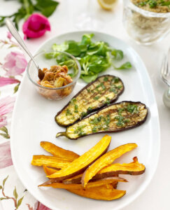 Ett fat med grillad aubergine med vitlöksdressing, sötpotatis och rabarberchutney.