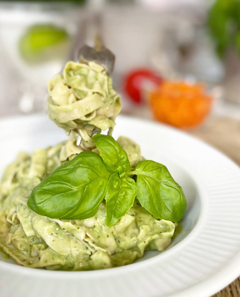 En djup tallrik med vegansk och glutenfri pastasås på avokado och bönpasta.