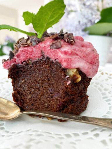Ett fat med en glutenfri och vegansk chokladmuffins med rosa frosting och mynta.