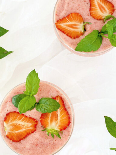 Två skålar nicecream - raw glass toppad med jordgubbar och mynta.