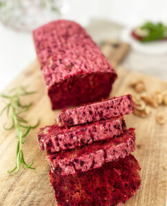 Uppskivat glutenfritt rödbetsbröd på en skärbräda.