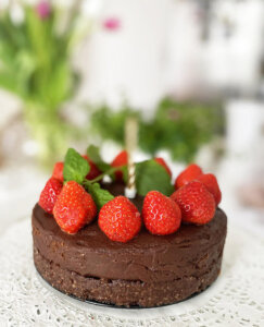 En vegansk tårta / chokladtårta raw toppad med jordgubbar och färsk mynta.