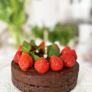 En vegansk tårta / chokladtårta raw toppad med jordgubbar och färsk mynta.