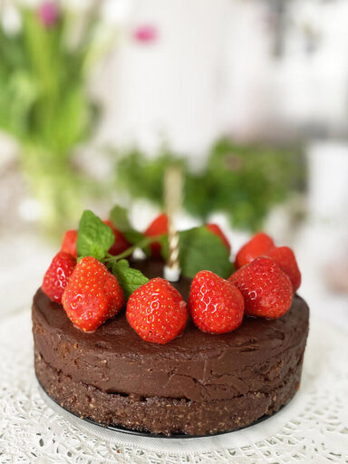 En vegansk tårta / chokladtårta raw toppad med jordgubbar och färsk mynta.