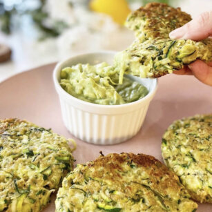 Zucchiniplättar doppas i avokadotzatziki - vegan.