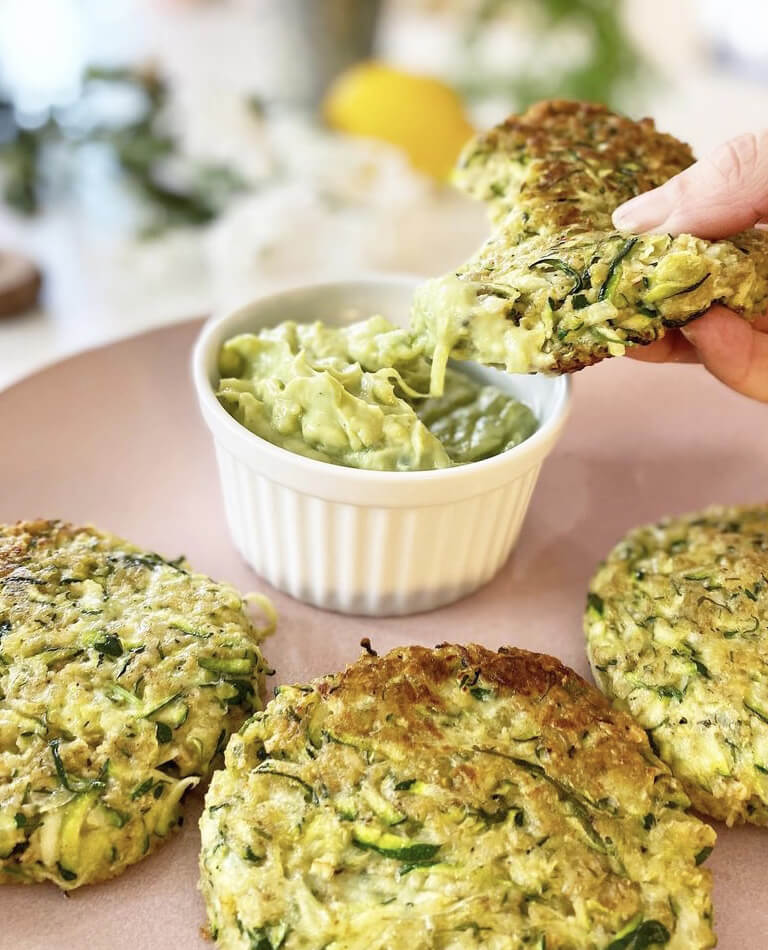 Zucchiniplättar doppas i avokadotzatziki - vegan.