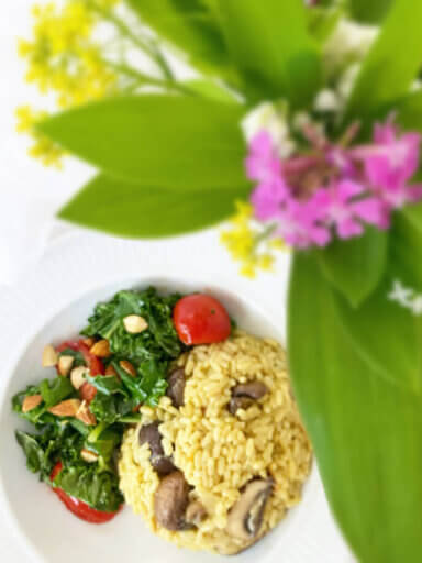 Ett fat med risotto vegan med en bukett blommor vid sidan om.