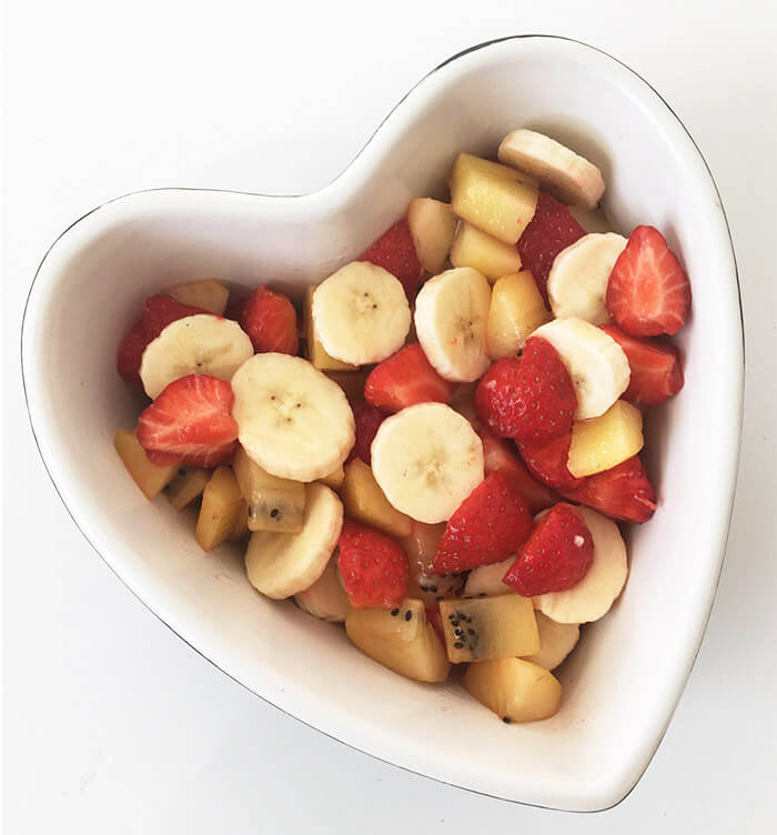 En hjärtformad skål med frukt och bär. 