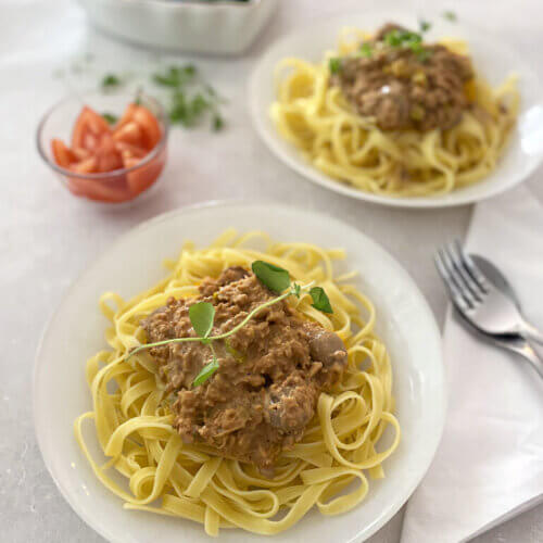 Två fat med vegansk krämig köttfärssås med spagetti.